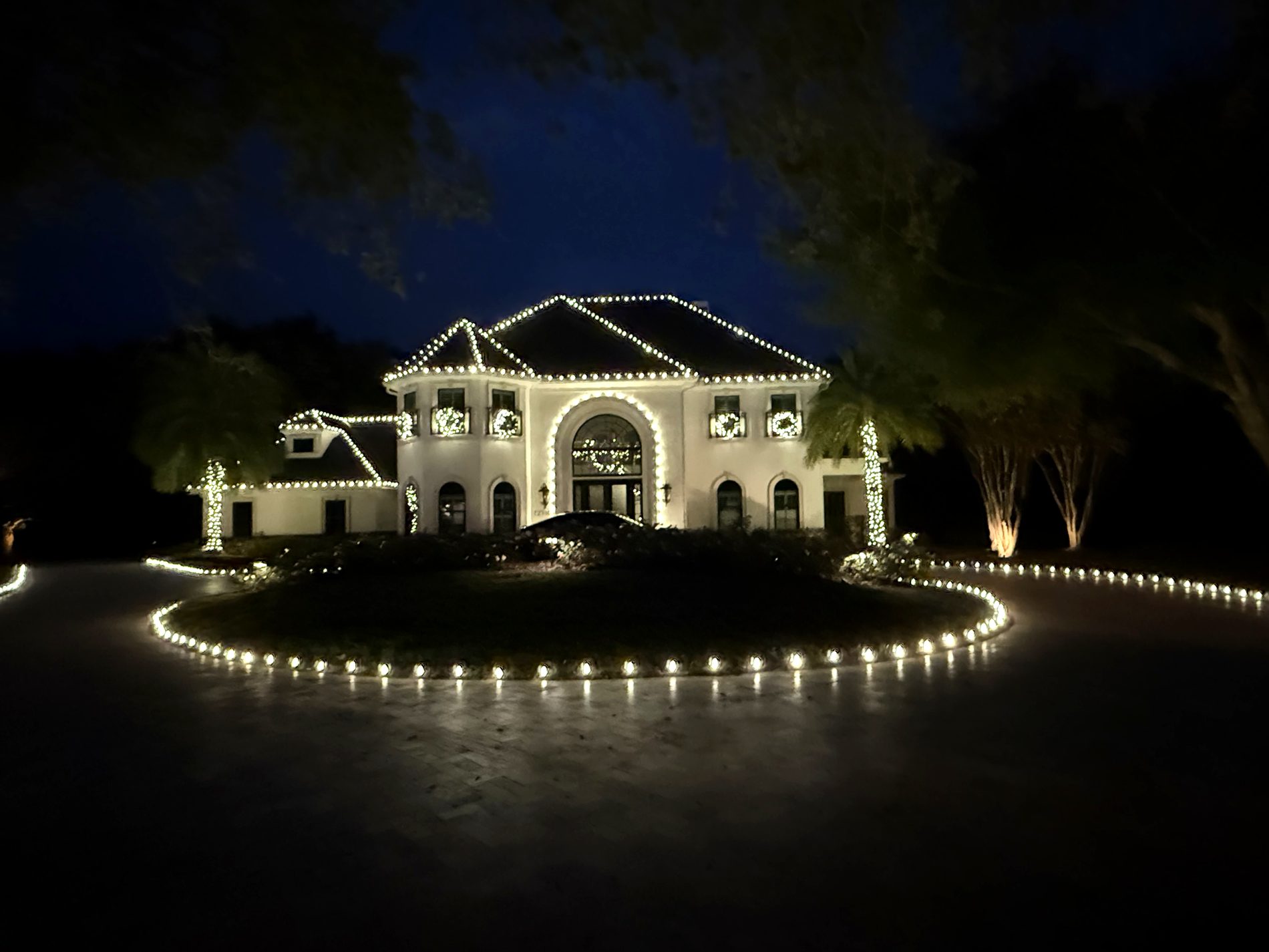 Central Florida home with professionally installed warm white Christmas lights at dusk